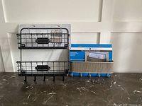 Photo showing two black metal wire mail and key organizers side by side on a table with white background.