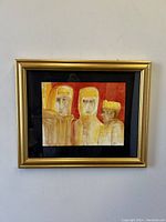 Framed watercolour painting showing three abstract heads in warm tones with a gold frame and black mat.