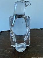 Front view of the clear glass eagle statue showing the detailed head, wings, and tail with polished finish.