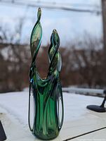 Front view of the tri-color Murano stalactite vase with a green to blue color gradient and amber-tipped spirals, set outdoors on a white surface.