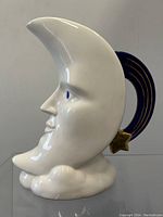 Front profile view of the white ceramic crescent moon face pitcher
