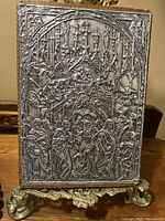 Front view of antique religious plaque with detailed silver relief, showing gothic style arches and multiple figures.