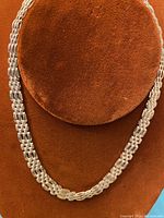 Front view of the braided sterling silver Italian choker displayed on a brown velvet bust.