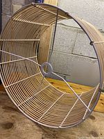 Side and angled view of open circular bamboo woven lampshade showing bamboo rods and metal frame