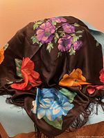 Full view of vintage Ann Taylor scarf showing colorful large floral prints on black fabric with fringe edges.