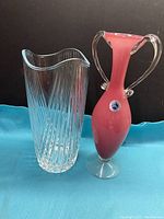 Two vintage glass vases: a clear crystal vase with diagonal cut pattern and a pink hand blown Murano vase with handles and label