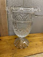 Full view of tall vintage cut crystal vase with ornate detailing and rolled rim.
