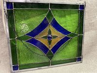 Front angle showing full stained glass window with leaded edges and hanging chain.