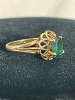 Side profile of ring showing green stone and openwork gallery