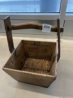 Antique wooden box with wide handle, showing front and side