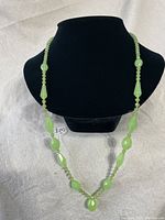 Full view of vintage jadeite faceted bead necklace displayed on black bust.