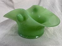 Side view of green jadeite hanging flower pot showing curved lip and nib on the side for rope or string.