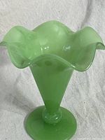 Full view of vintage jadeite glass vase with rolled rim showing flared top and pedestal base.
