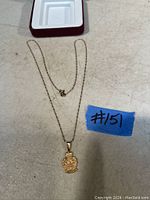 Full view of the 10K gold necklace chain with attached Quebec Provincial Police pendant and box.