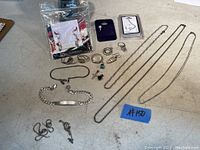 Overview of the sterling silver jewelry lot showing 3 neck chains, 2 bracelets, multiple rings, earrings and pendants arranged on a surface.