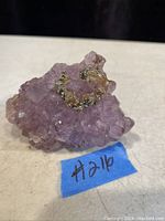 Amethyst cluster with quartz base top view showing purple crystals and mineral inclusions.