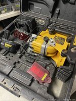 Open hard plastic carrying case containing the DeWalt cordless rotary laser, charger, red glasses, and accessories.