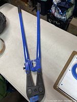 Full view of the 36 inch heavy duty chain cutter with blue handles and black cutting head on a white surface.