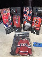 Photo showing Alexander Ovechkin and Connor McDavid mini hockey stick collectibles in black Tim Hortons branded boxes alongside Montreal Canadiens holiday ornament still sealed in packaging.