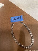 Sterling silver chain bracelet laid flat with lobster clasp visible, showing linked chain design and excellent condition.