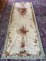 Full view of rectangular floral tapestry panel on patterned rug background