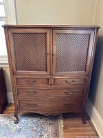 Front view of walnut dresser showing two cabinet doors with diamond lattice detailing, four drawers with ornate metal handles, curved legs, and decorative base trim.