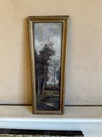 Full view of framed antique oil painting showing naturalistic landscape with trees and pond, vertical format.