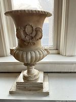 Front view of marble urn on stepped base