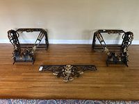 Full view photo showing the iron frames and the separate lion's head element on the floor.