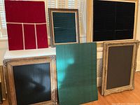 Several framed jewelry displays arranged together showing various sizes and colors of foam inserts designed for rings, necklaces, and brooches.