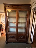 Front view of the full cabinet showing glass doors and base details