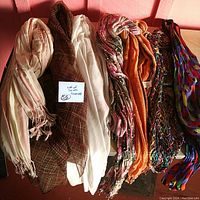 Full view of the 7 assorted vintage scarves rolled together showing variety in colors and fabric types.
