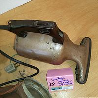 Photo showing the Hoover handheld vacuum cleaner's side profile with power cord and pink auction note alongside