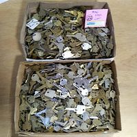 Two large cardboard boxes filled with a variety of vintage keys in mixed metal finishes and shapes.