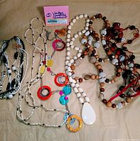 Full lot of six vintage necklaces displayed together, showing mix of natural bead tones with colorful hoop and disc pendants