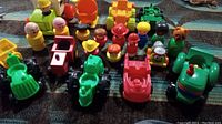 Front view showing 22 colorful vintage Fisher Price toys including vehicles and figures