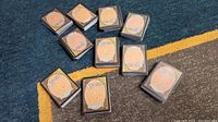 Ten stacks of Magic the Gathering cards showing the backs with the Magic logo. Each stack contains approximately 50 cards.