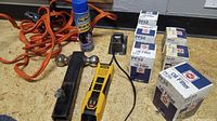 View of assorted AC Delco oil filters in original boxes labeled PF52, PF47, PF35, an orange jumper cable set, black 2 1/2 inch hitch ball with mount, yellow plug-in power outlet socket, and a blue spray can.