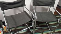 Pair of two vintage style metal chairs with chrome frames and black cloth coverings
