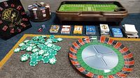 Photo showing entire lot including dice clock, poker chips, playing cards, roulette wheel, craps table, and serving dish.