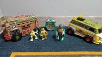 Full lot of TMNT figures, alarm clock, and vehicles arranged on carpet showing all items