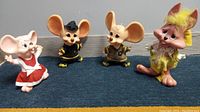 Four vintage plastic dolls - two firefighter Freddy mice, a bunny doll, and a piggy bank mouse doll in various outfits and colors.