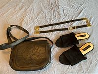 Black US Polo Association shoulder bag with embossed logo, Steven by Steve Madden black suede slide sandals size 10, large black leather belt with gold hardware, and an additional smaller belt/strap.
