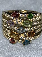 Front view of ring showing stacked rows with colored gemstones and clear pave stones