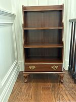 Frontal view of three-shelf bookcase with drawer and Queen Anne style legs