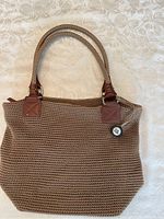 Front view of the brown woven ladies hand bag showing braided handles.