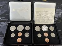 Two Canadian coin specimen sets from the 1970s displayed in open black velvet-lined presentation cases, each containing seven coins and an info card.