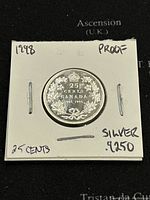 Obverse side of a 1998 Canadian 25 cents silver coin showing the value, maple leaf wreath, and anniversary dates.