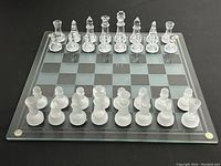 Top-down view of glass chess set with all pieces arranged at starting positions on the glass chess board.