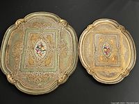 Photo of the large rectangular and small oval gold-tone service trays with floral motif and embossed patterns.